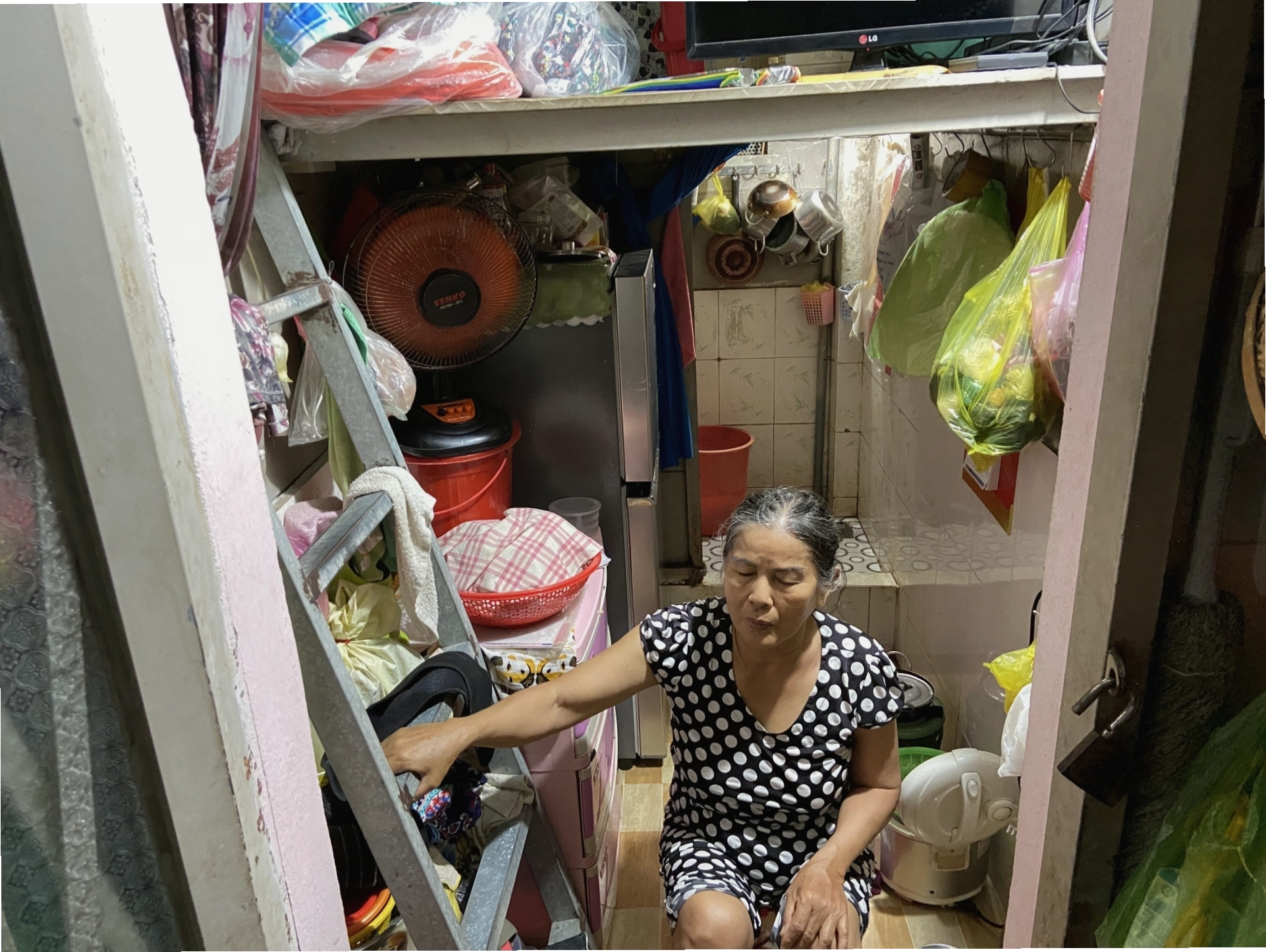 Bà Nguyễn Thị Hoa (66 tuổi) sinh sống trong căn phòng chật hẹp dưới chân cầu thang lô 8 Cư Xá Thanh Đa