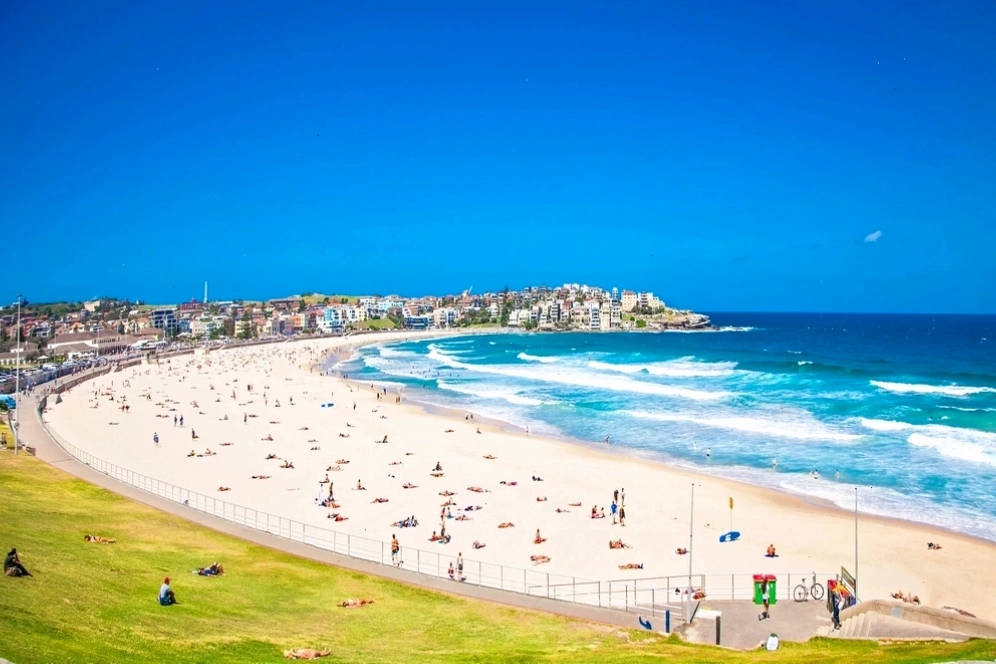 Bãi biển Bondi rực rỡ trong nắng hè, là điểm đến lý tưởng để tắm nắng, lướt sóng và tận hưởng không khí biển sôi động