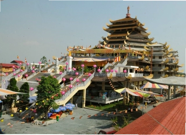 Cổng tam quan Pháp viện Minh Đăng Quang với không gian cây xanh mát mẻ
