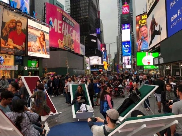 Du khách nghỉ chân ngắm các tòa nhà cao tầng tại Times Square