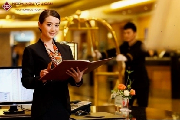 Hình ảnh nhân viên lễ tân đang tươi cười chào đón khách