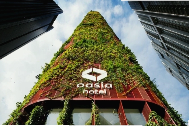Khách sạn Oasia Hotel Downtown với mặt tiền phủ đầy cây xanh
