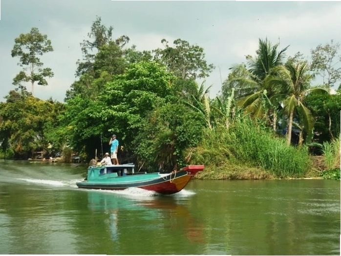 Một con thuyền nhỏ lướt trên sông, tạo nên bức tranh tĩnh lặng của hình ảnh sông nước miền tây