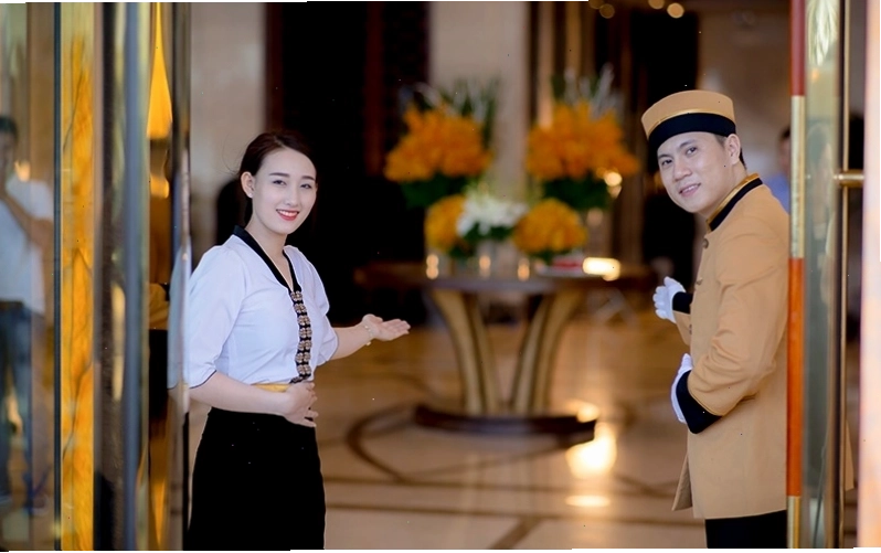 Nhân viên cửa chào đón khách đến với khách sạn