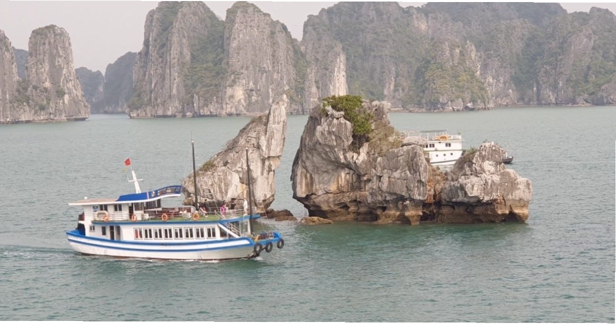 Tàu du lịch di chuyển gần Hòn Trống Mái với biển báo an toàn